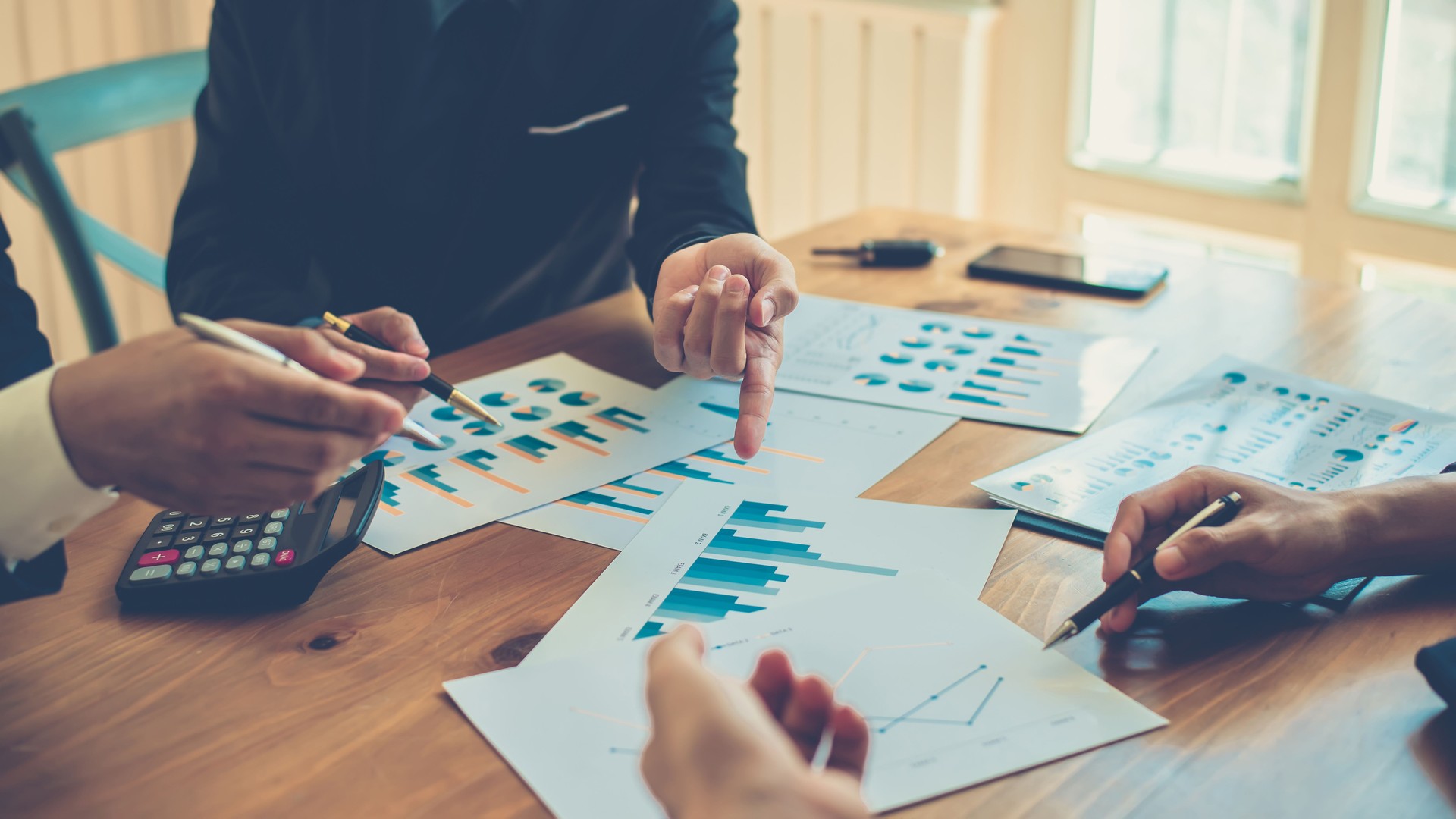 Group of business people discussing financial graphs during the meeting.